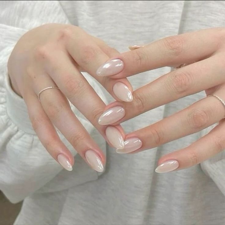 Manos delicadas mostrando uñas con polygel de color natural, con un acabado suave y elegante